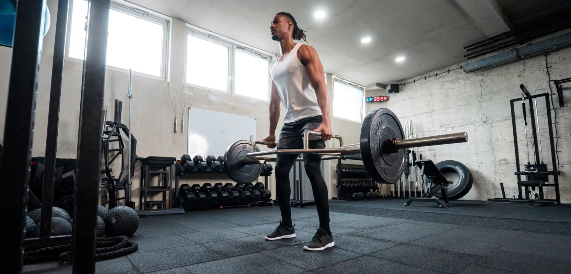 Man lifting heavy barbell in a gym with intense focus.