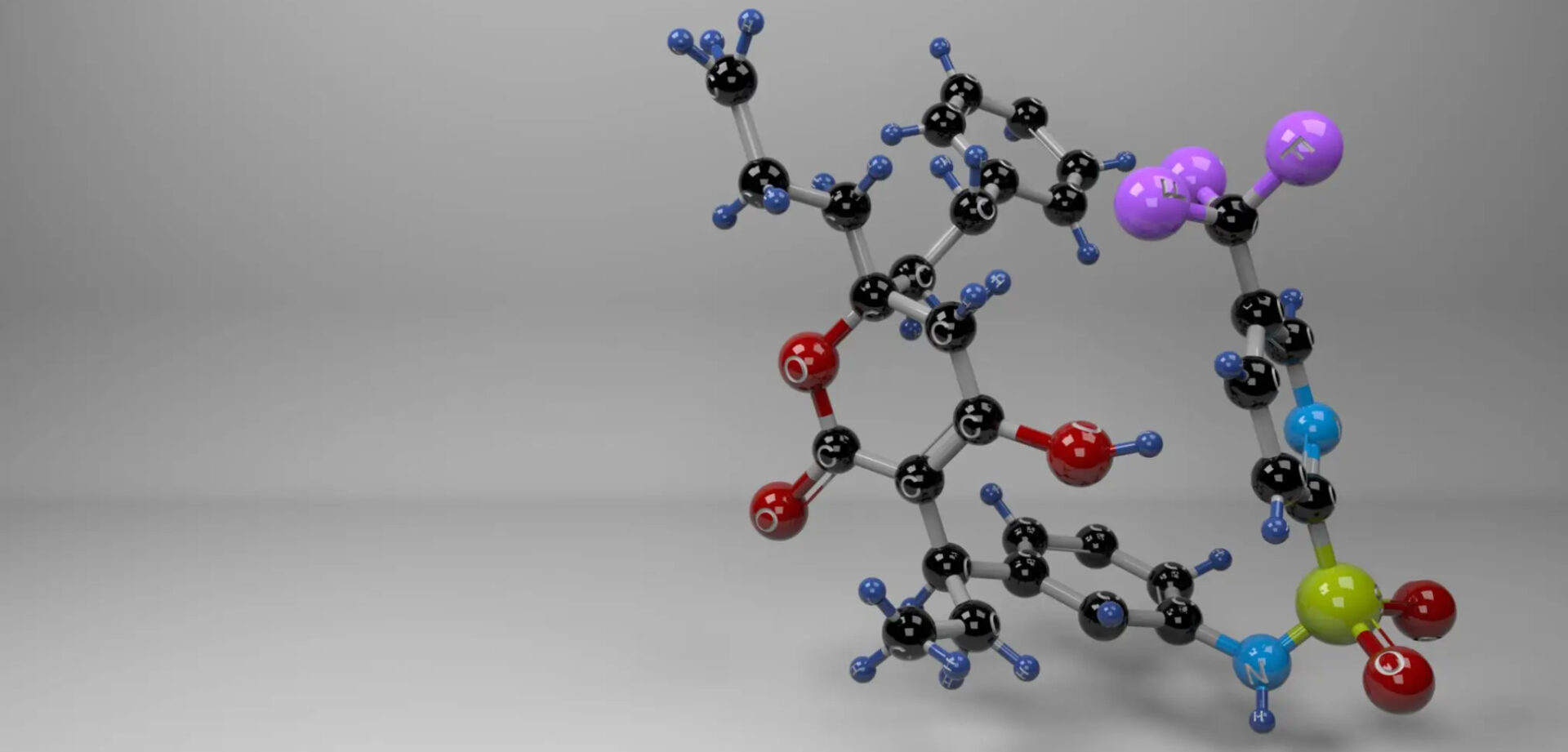 3D molecular structure model with colored atoms on a gray background.