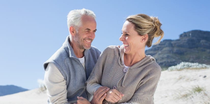 A joyful mature couple laughing together outdoors.