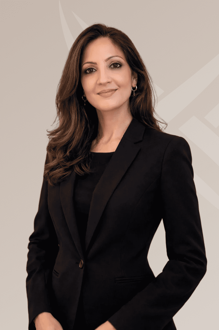 Professional woman in a black blazer posing confidently.