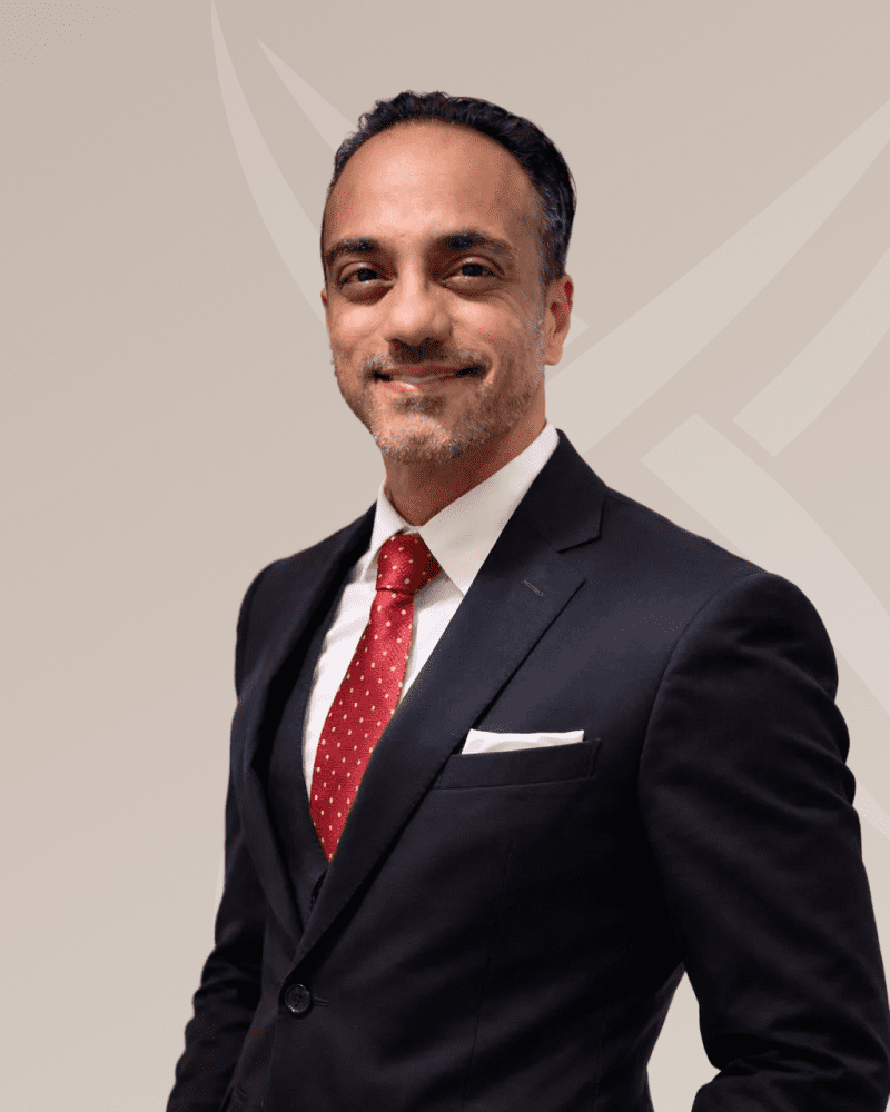 Professional man in a suit with red tie smiling confidently.