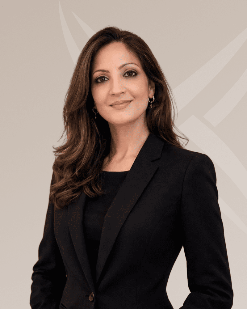 Professional woman in a black blazer smiling confidently.