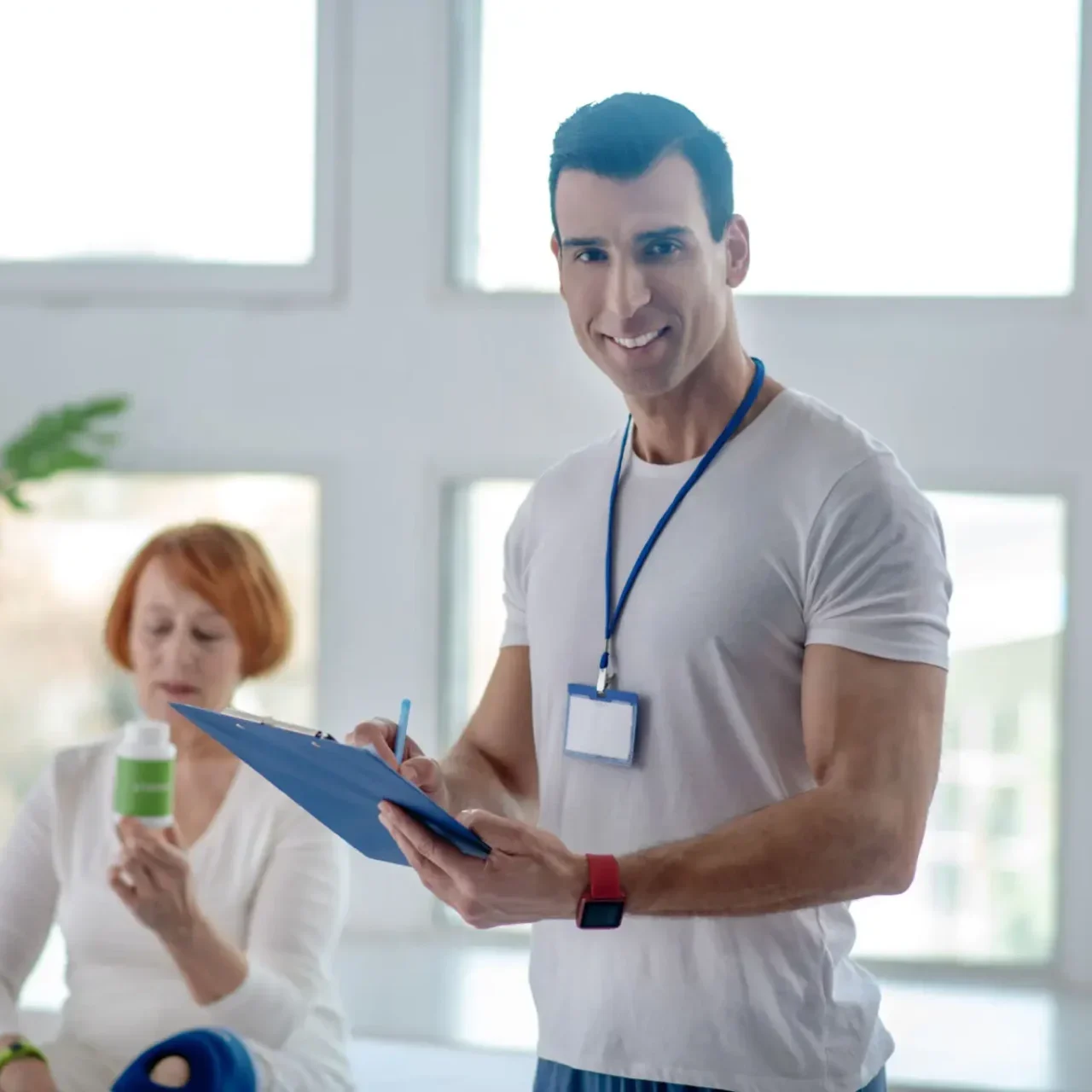 Man with clipboard and badge in a bright office.